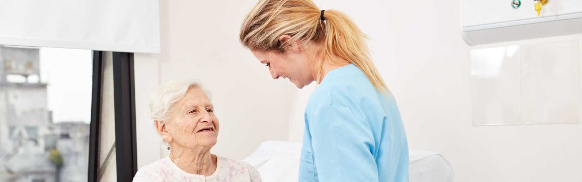 woman standing and sitting elderly woman