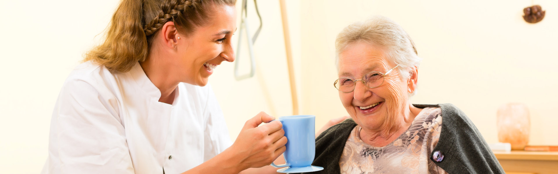 woman giving a mug to eldely woman