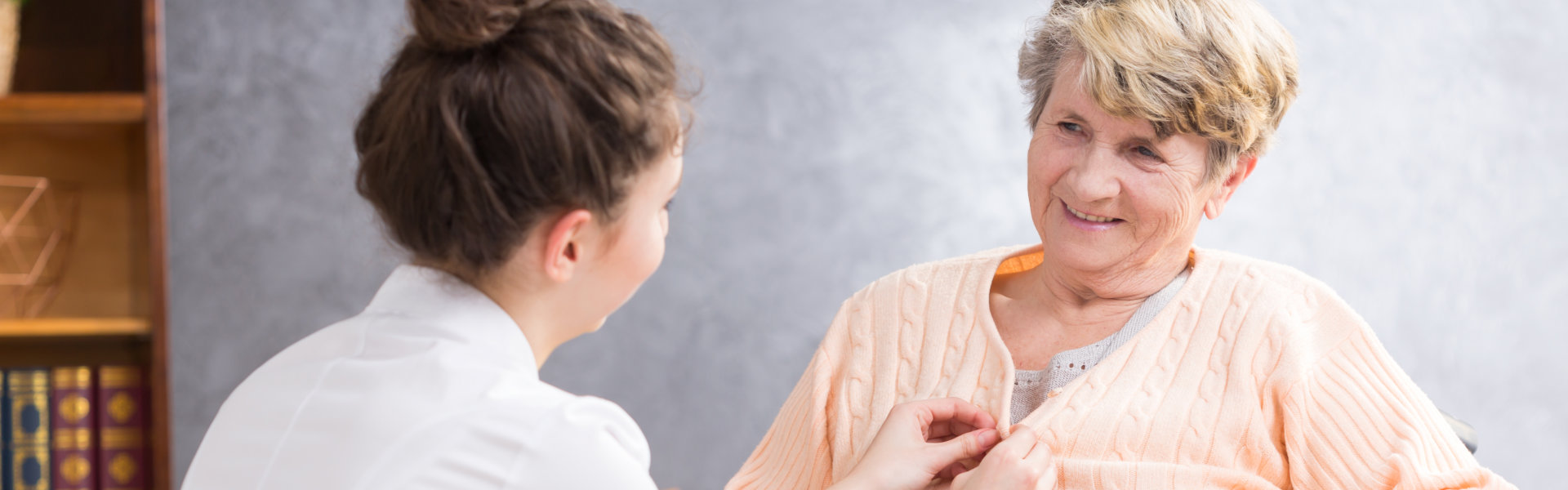 woman putting buttons to elderly dress